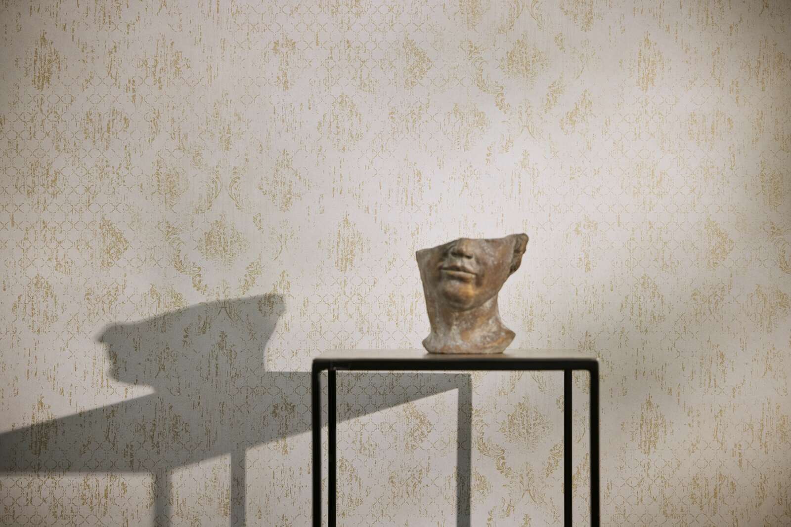 Dezente Vliestapete mit klassischem Ornamentmuster und schimmernden Akzenten, fein strukturiert – Creme, Gold, Metallic