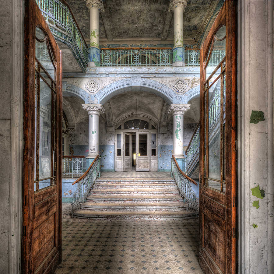 verlassenes Gebäude, Eingangsbereich, große Treppe, antike Säulen, abblätternde Farbe