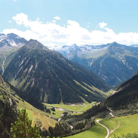 Berglandschaft, Tal, grüne Wiesen, serpentine Strasse, alpine Szene