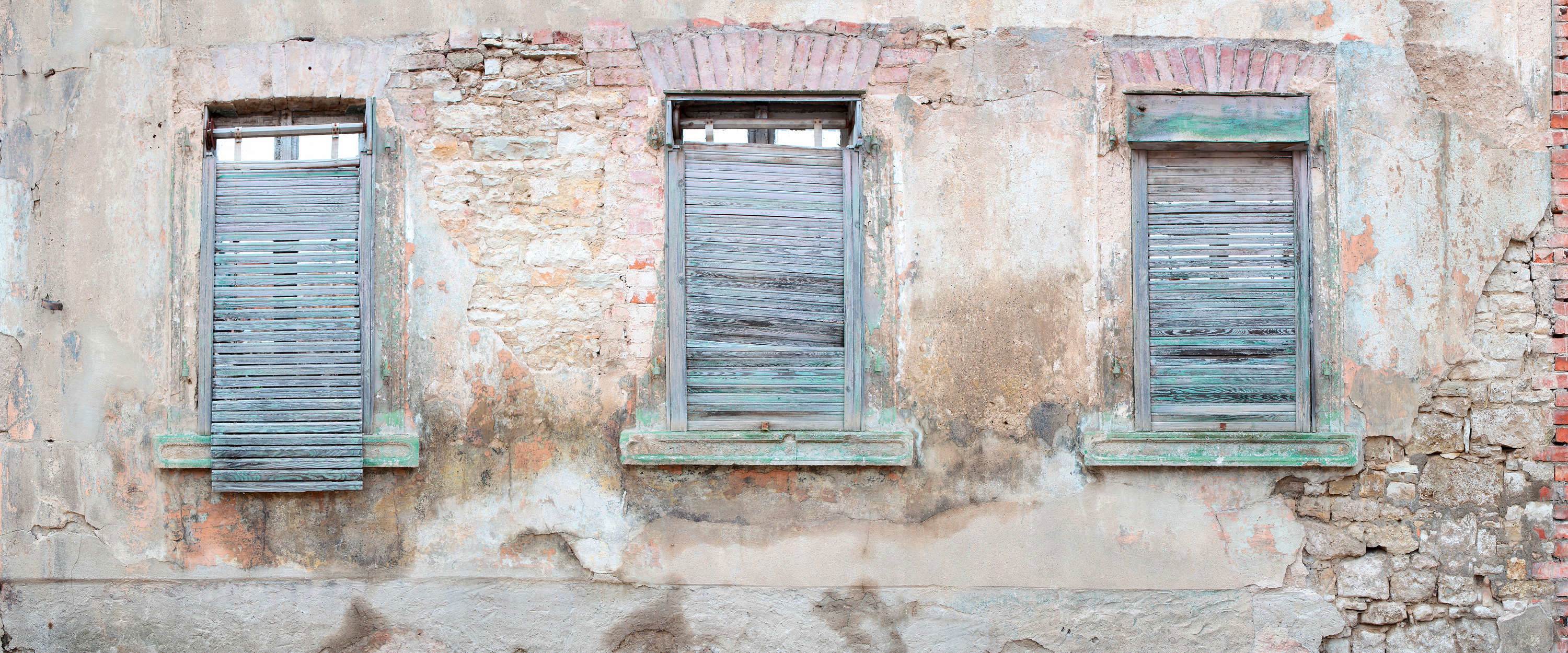             Fototapete Ziegelmauer mit rustikalen Fensterläden und Rundbögen
        