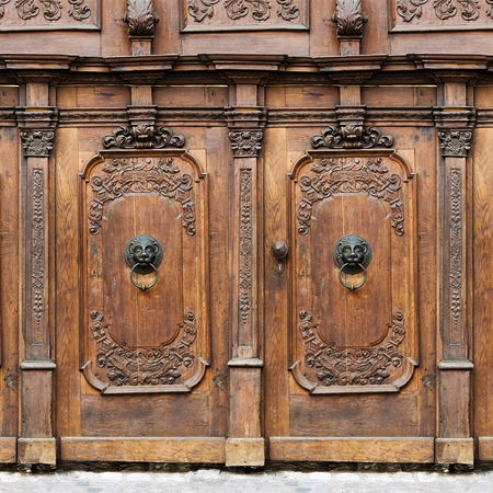 wooden doors, carved panels, double doors, metal door knockers, fire door accents