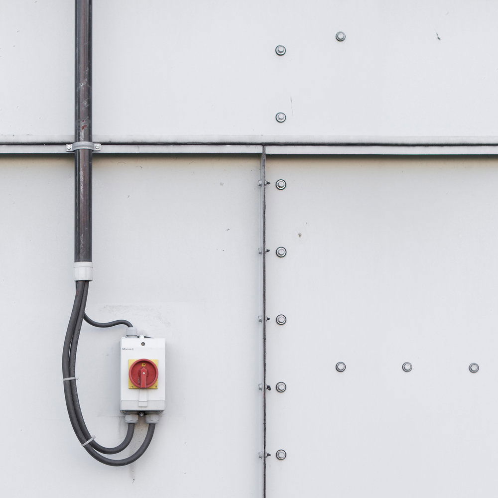             Fototapete Vliestapete Industrial Look – Helle Containerwand mit Schaltern – Grau, Weiß
        