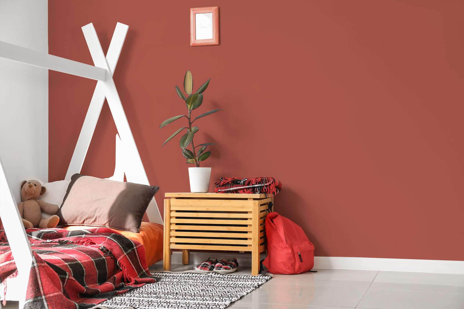 Kinderzimmer, rote Wand, Holzkommode, Bettrahmen, Pflanze, Teddy, Plaid