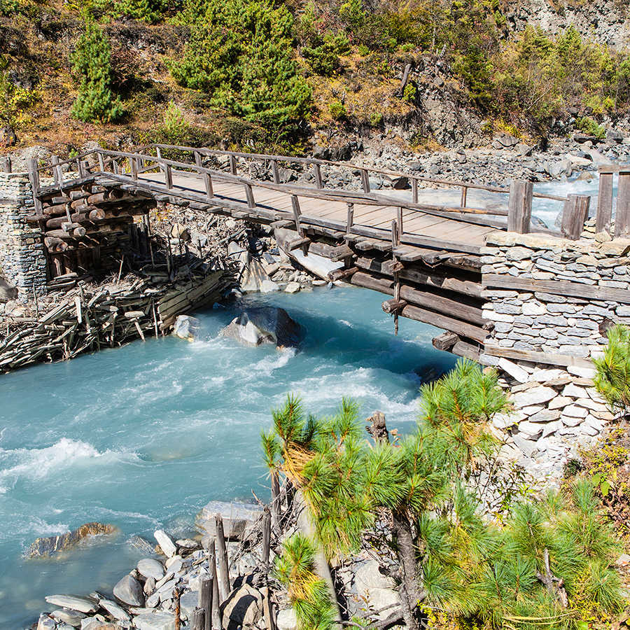 Holzbrücke, Fluss, Steinmauer, Holztürme, Waldlandschaft