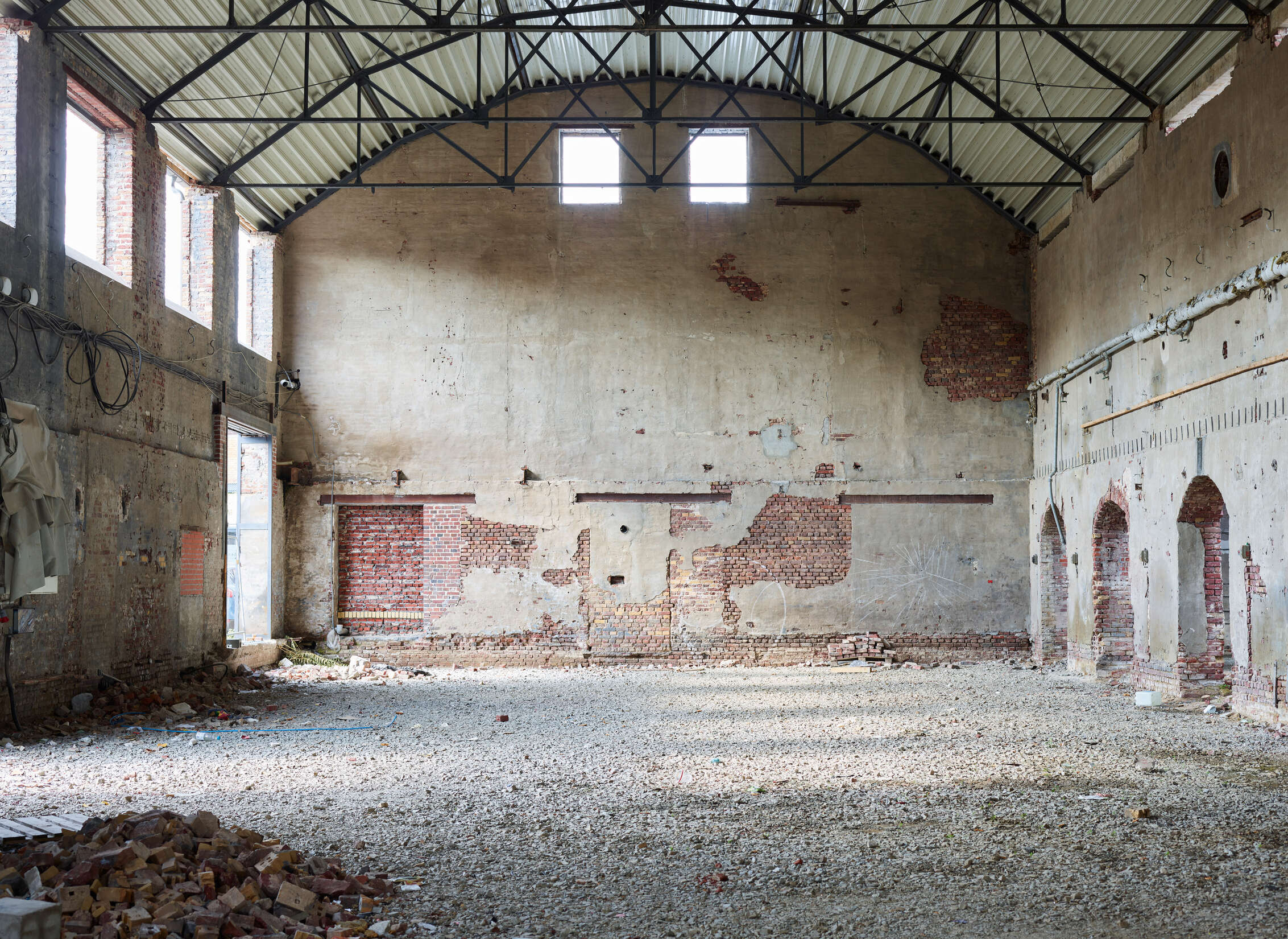 leerer Lagerraum, verwahrlostes Interieur, Backsteinwand, Betonboden, industrieller Raum