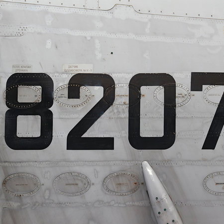 tail number, aircraft fuselage, metal surface, painted numbers, sticker marks